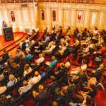 circa 100 Personen sitzen in Saal